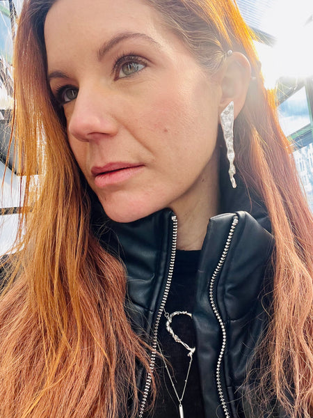 Long Glacier Triangle Earrings by Elke Van Dyke, handcrafted in sculpted sterling silver, inspired by glacial forms and minimalist, sculptural design. Shown on display ear.