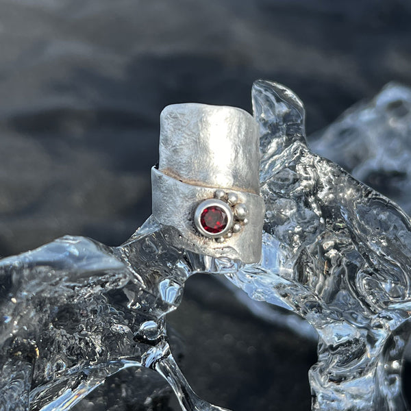 One-of-a-kind garnet ring from Elke Van Dyke’s Glacier Collection – handcrafted in sterling silver with raw sculptural texture and 6mm round faceted garnet.