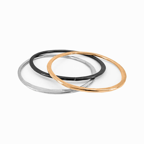 Set of three sculptural sterling silver bangles. Lightweight, hand-formed stacking bracelets by Elke Van Dyke, crafted for daily wear.