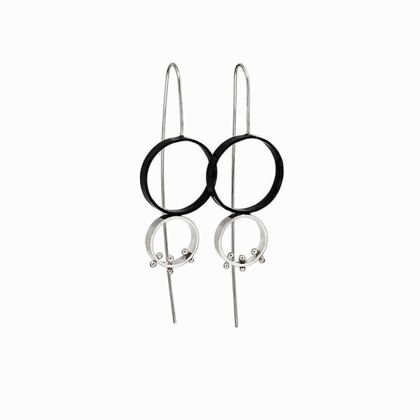 Two-tone Lunar Eclipse Earrings—sculptural moons in oxidized and polished sterling silver, evoking a celestial eclipse by Elke Van Dyke.