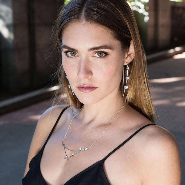 Moon Lapse earrings in sterling silver, a sculptural crescent shape handcrafted for lightweight celestial elegance by Elke Van Dyke.