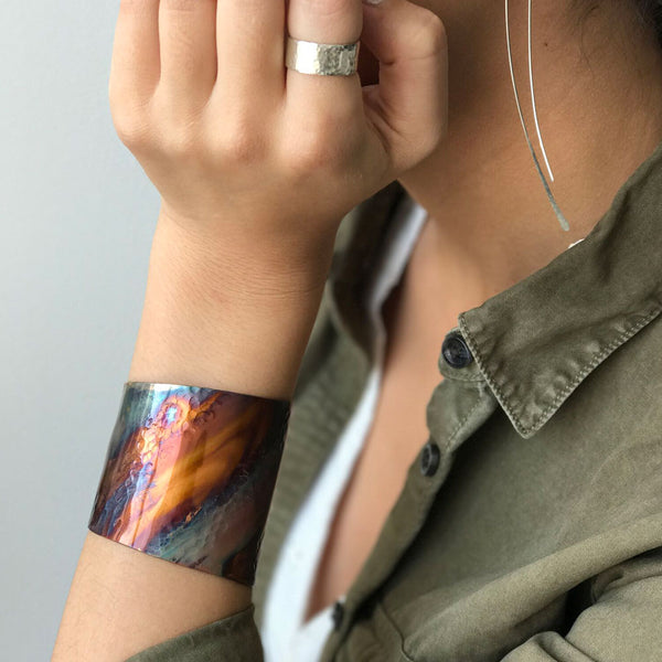 Rainbow Copper Cuff Bracelet with flame-painted finish, handcrafted by Elke van Dyke. Unique hues and textures create a bold, wearable art piece. 1.5" width.