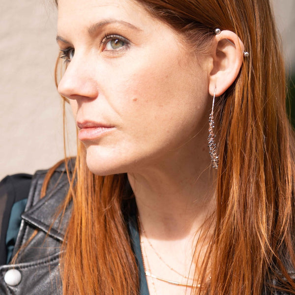 Silver Cocoon Threader Earrings handcrafted by Elke Van Dyke. Interwoven sterling silver and faceted hematite stones, organically spiraling into a wishbone shape. Available in 3 sizes.