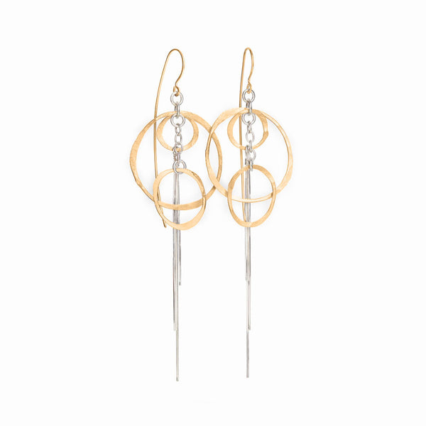 Gold and silver earrings with circular and chain design on a white background. Gold Orbit Earrings statement jewelry by Elke Van Dyke.
