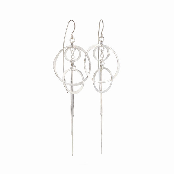 Orbit Earrings in sterling silver with flowing dangle design. Handmade minimalist statement jewelry by Elke Van Dyke.