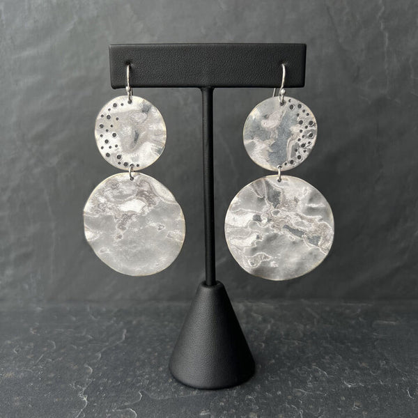 Silver Penumbra Earrings—handcrafted high-polish sterling silver medallions with fluid sculptural form by Elke Van Dyke.