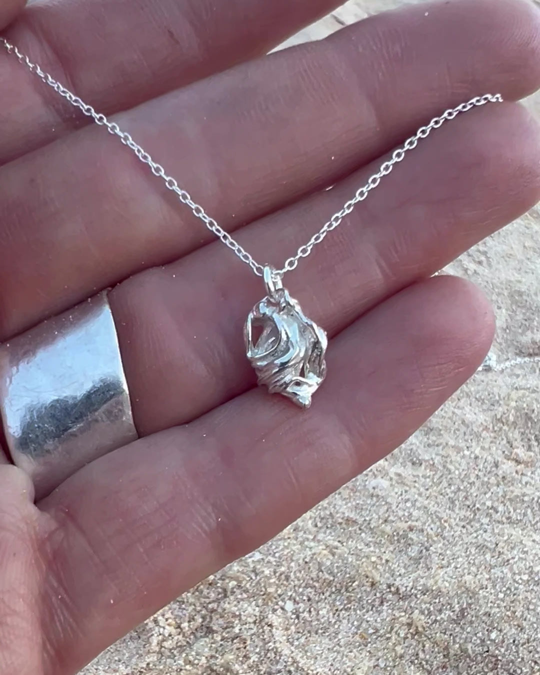 Video of Coração Heart Necklace – Handmade Sterling Silver Anatomical Heart Pendant Necklace by Elke Van Dyke, shown in palm of hand for scale.